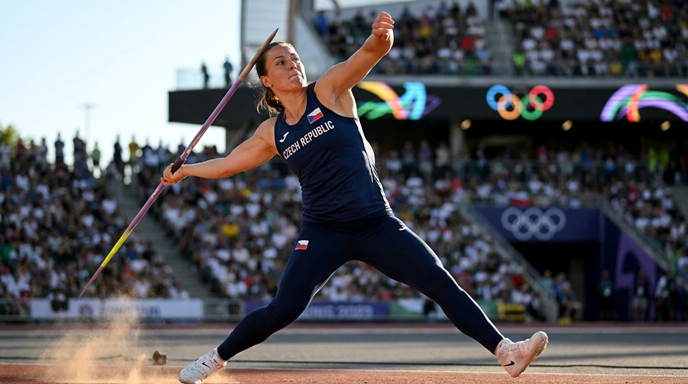 Professional athletic photography of a female javelin thrower in mid-motion, wearing a Czech Republic team uniform.